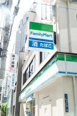 a sign for a family mart on the side of a building at YadoyaTamachi 101 in Tokyo