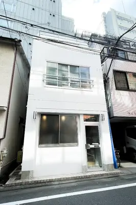 a white building on the side of a street at YadoyaTamachi 101 in Tokyo