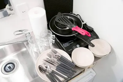 a kitchen sink with plates and utensils on it at YadoyaTamachi 101 in Tokyo