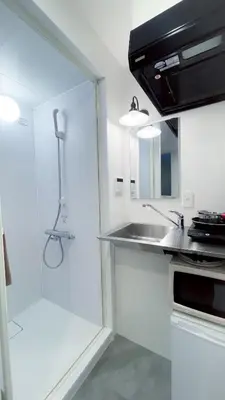 a white kitchen with a sink and a shower at YadoyaTamachi 101 in Tokyo