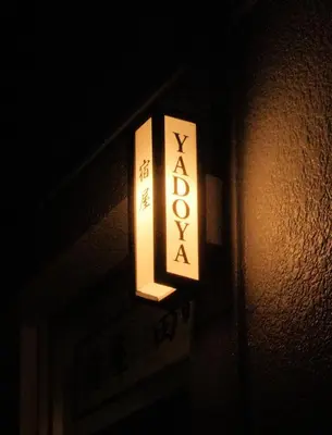 a lit sign on the side of a building at YadoyaTamachi 101 in Tokyo