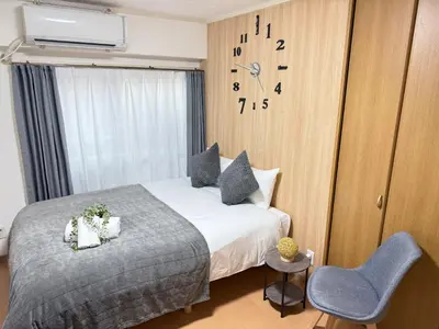 a bedroom with a bed and a clock on the wall at Shinjuku Area 42 Shinjuku Apartment in Tokyo