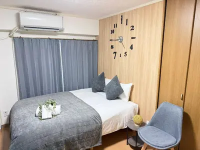 a hotel room with a bed and a clock on the wall at Shinjuku Area 42 Shinjuku Apartment in Tokyo