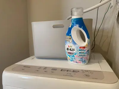 a bottle of water sitting on top of a washing machine at PRISM Inn Tateishi in Tokyo