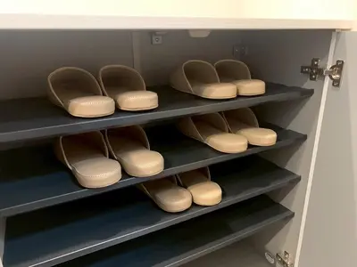 a row of shoes sitting on shelves in a closet at PRISM Inn Tateishi in Tokyo
