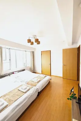 a large white bed in a room with wooden floors at \u6771\u4eac\u90fd\u5fc3 \u6751\u4e0a\u7fa9\u7537\u8a2d\u8a08 112\u5e73\u7c73\u9ad8\u7d1a\u8c6a\u90b8 \u5b8c\u5168\u8cb8\u5207 \u6c60\u888b\u96fb\u8eca6\u5206 \u65b0\u5bbf\u6e0b\u8c37\u76f4\u901a \u6620\u753b\u9928 WiFi12\u4eba WAGAMAMA\u5c0f\u7af9\u5411\u539f3\u968e in Tokyo