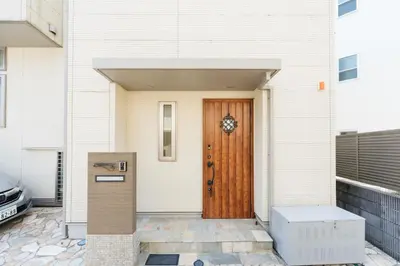 a front door of a white house with a wooden door at Tokyo Platinum Comfort in Tokyo