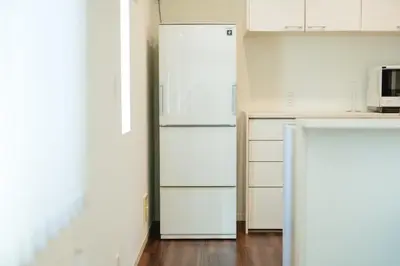 a kitchen with white cabinets and a white refrigerator at Tokyo Platinum Comfort in Tokyo