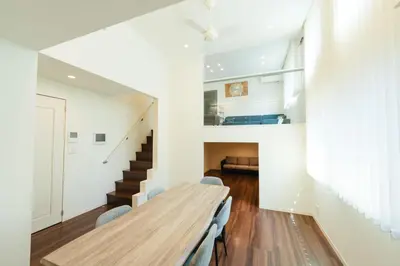 a living room with a wooden table and stairs at Tokyo Platinum Comfort in Tokyo