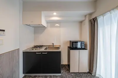 a small kitchen with a sink and a microwave at Apartment Hotel 11 Asakusa 1 in Tokyo