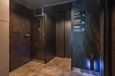a elevator in a building with a sign on the wall at Apartment Hotel 11 Asakusa 1 in Tokyo