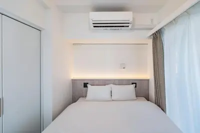 a small bedroom with a bed and a window at Apartment Hotel 11 Asakusa 1 in Tokyo