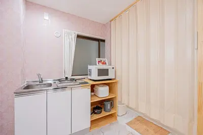 a small kitchen with a sink and a microwave at Ueno home2 10-minute walk from Ueno Station, 4-minute walk from Inaricho Station, 10-minute walk to Asakusa, 1F in Tokyo