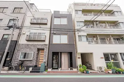 an apartment building on the corner of a street at Ueno home2 10-minute walk from Ueno Station, 4-minute walk from Inaricho Station, 10-minute walk to Asakusa, 1F in Tokyo