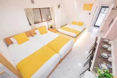 a bedroom with two beds with yellow and white sheets at Ueno home2 10-minute walk from Ueno Station, 4-minute walk from Inaricho Station, 10-minute walk to Asakusa, 1F in Tokyo