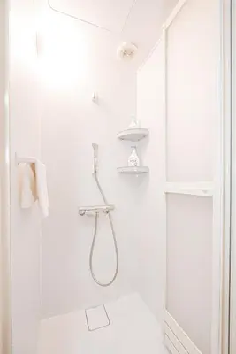 a white bathroom with a shower with a glass door at Ueno home2 10-minute walk from Ueno Station, 4-minute walk from Inaricho Station, 10-minute walk to Asakusa, 1F in Tokyo