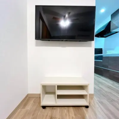 a flat screen tv on a wall with a white table at \u6771\u7acb\u77f34\u4e01\u76ee-47 in Tokyo
