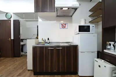a small kitchen with a sink and a microwave at Shinjuku family apartment in Tokyo