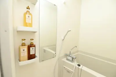 a bathroom with a mirror and some bottles on the wall at Shinjuku family apartment in Tokyo