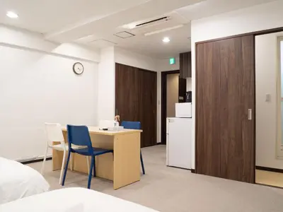 a room with a table and chairs and a kitchen at Shinjuku family apartment in Tokyo