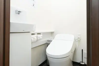 a white bathroom with a toilet and a sink at Shinjuku family apartment in Tokyo