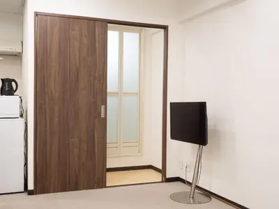 a room with a door with a television in it at Shinjuku family apartment in Tokyo