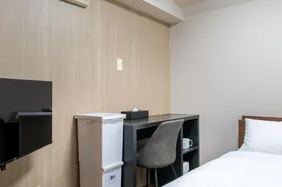 a bedroom with a desk and a bed and a chair at Sleep Inn Gotanda in Tokyo