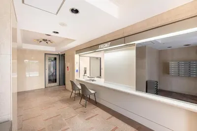 a lobby with a reception desk and chairs at Sleep Inn Gotanda in Tokyo