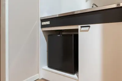 a black tv in a cabinet in a room at Sleep Inn Gotanda in Tokyo
