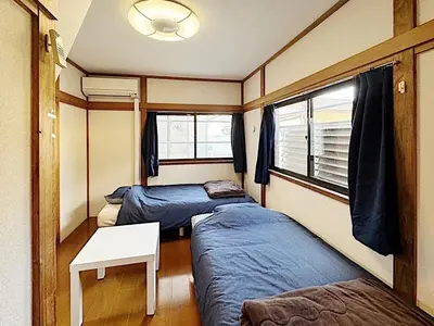 a room with two beds and a table in it at Tokyo Stay sugamo House in Tokyo