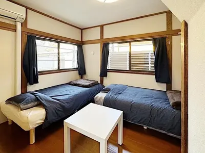 a small room with two beds and a table at Tokyo Stay sugamo House in Tokyo