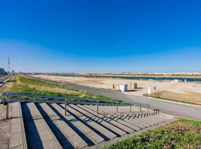 a bench on the side of a road next to a beach at SkyTreeStayHotel 3, 8-minute walk from Yahiro Station, lovely new building, near Ara river, can see Sky Tree in Tokyo