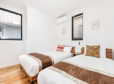 a bedroom with two beds and a window at SkyTreeStayHotel 3, 8-minute walk from Yahiro Station, lovely new building, near Ara river, can see Sky Tree in Tokyo