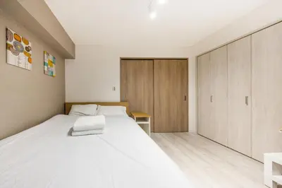 a bedroom with a white bed and a wooden cabinet at 203 8 min walk to Ikebukuro 6 min walk to Kanamecho Station 25m Max 2 people Direct access to Tokyo, Shinjuku, Shibuya, Ueno in Tokyo