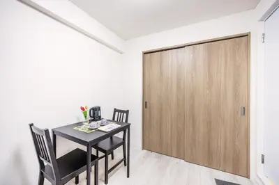 a dining room with a table and chairs and a wooden door at 203 8 min walk to Ikebukuro 6 min walk to Kanamecho Station 25m Max 2 people Direct access to Tokyo, Shinjuku, Shibuya, Ueno in Tokyo