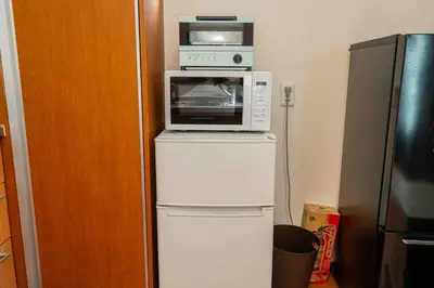 a microwave oven sitting on top of a refrigerator at Sky Tree Stay Hotel, 4-minute walk from Keisei Hikifune Station, detached house with parking, very convenient location in Tokyo