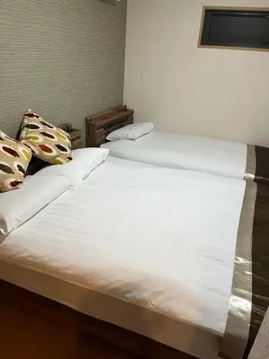 two beds in a room with white sheets and pillows at Sky Tree Stay Hotel, 4-minute walk from Keisei Hikifune Station, detached house with parking, very convenient location in Tokyo