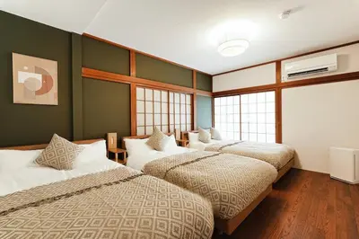 two beds in a room with green walls and windows at Skytree 1 Stop , 5-min Walk , 8 Guests , Fast WiFi in Tokyo