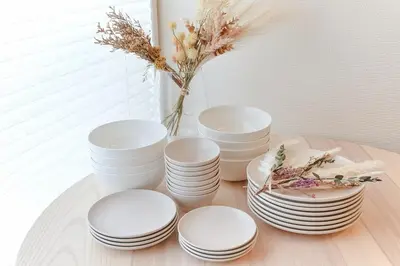 a group of white plates and a vase on a table at Skytree 1 Stop , 5-min Walk , 8 Guests , Fast WiFi in Tokyo
