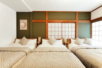 three beds in a room with green walls and windows at Skytree 1 Stop , 5-min Walk , 8 Guests , Fast WiFi in Tokyo