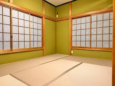 an empty room with green walls and windows at K2 A house in Kita-senju in Tokyo