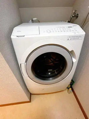 a washing machine in the corner of a room at K2 A house in Kita-senju in Tokyo