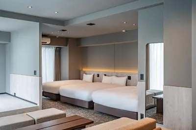 a hotel room with two beds and a couch at Apartment Hotel 11 Asakusa 2 in Tokyo