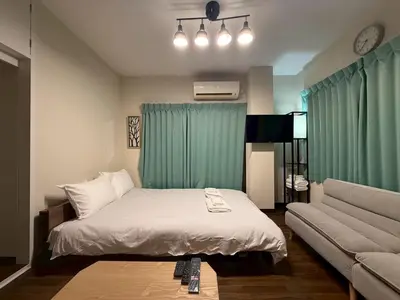 a small bedroom with a bed and a couch at \u30b3\u30fc\u30dd\u5ca1\u5d0e301 in Tokyo