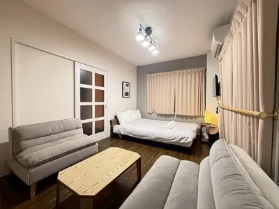a living room with a couch and a bed at \u30b3\u30fc\u30dd\u5ca1\u5d0e302 in Tokyo