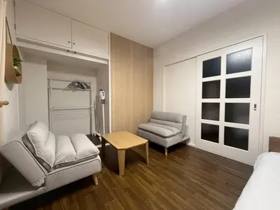 a room with a bed and a couch and a chair at \u30b3\u30fc\u30dd\u5ca1\u5d0e302 in Tokyo