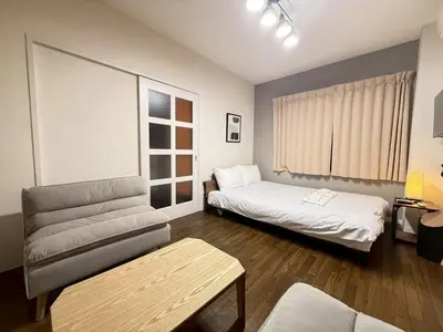 a small room with two beds and a couch at \u30b3\u30fc\u30dd\u5ca1\u5d0e302 in Tokyo