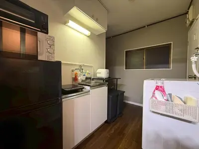 a kitchen with a black refrigerator and white cabinets at \u30b3\u30fc\u30dd\u5ca1\u5d0e302 in Tokyo