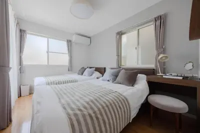 a bedroom with two beds and a desk and two windows at Entire Home in Sangenjaya, 2-stops to Shibuya, and Shinjuku, Lani's Place at Sangenjaya in Tokyo