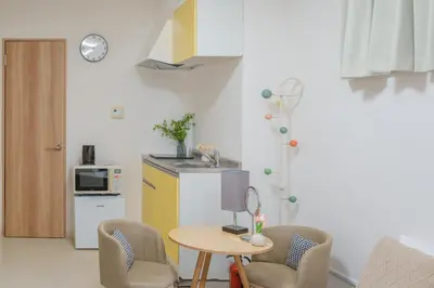 a small kitchen with a table and two chairs and a table at 3 minutes to Shinjuku by subway-Nakanokaikan I in Tokyo